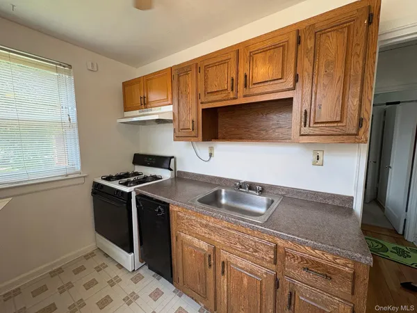 a kitchen with granite countertop a sink stove and microwave