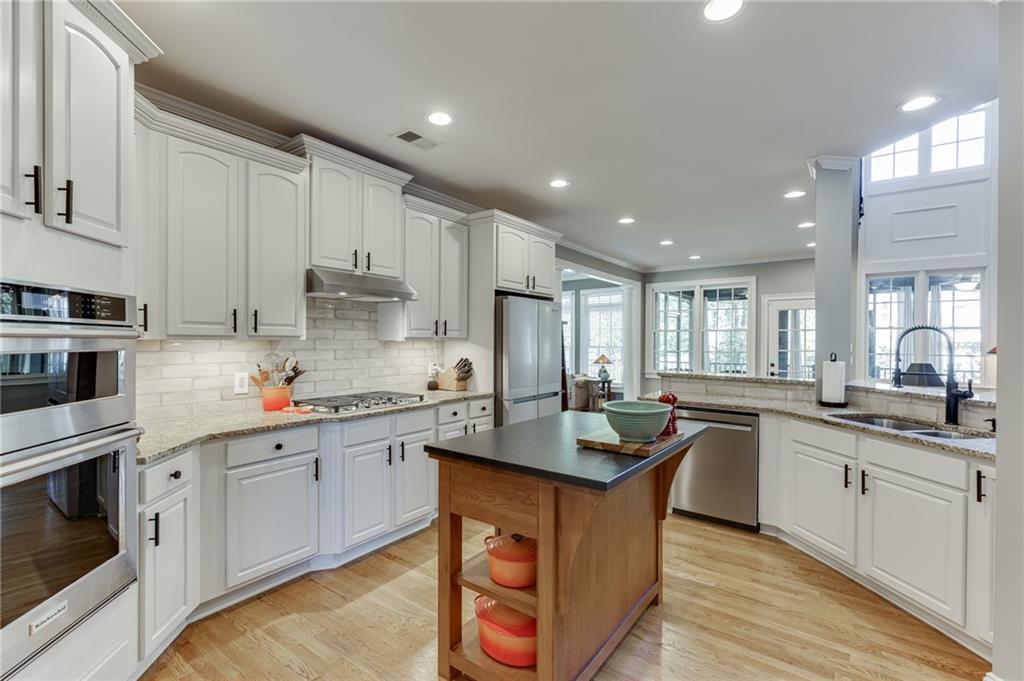 2758 Pathview Drive Dacula, GA 30019 - Photo 2 of 48 a kitchen with stainless steel appliances granite countertop a sink a stove and cabinets