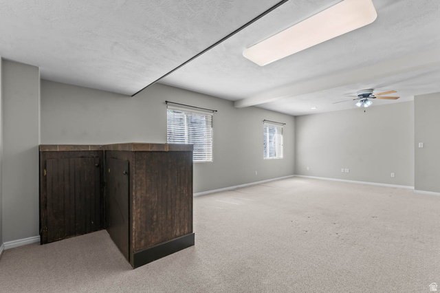 1417 Blacksmith Lane Draper, UT 84020 - Photo 26 of 57 Spacious room featuring light-toned carpeting, two windows with blinds, and a built-in dark wood-finish cabinet with a tiled countertop