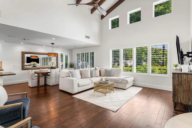 a dining room with furniture a chandelier and wooden floor