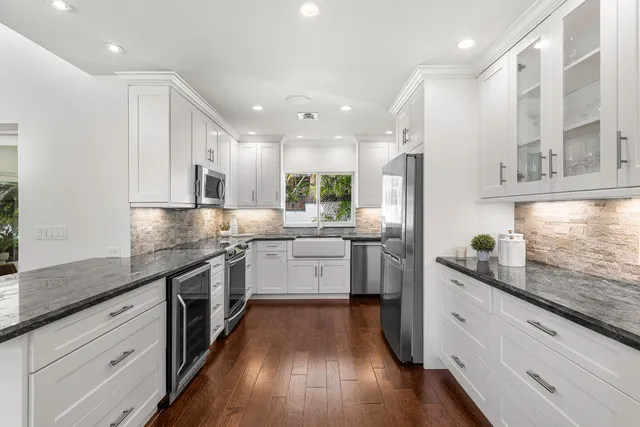 a kitchen with stainless steel appliances granite countertop a sink stove and wooden floor