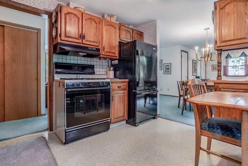 61 Hickory Road Sudbury, MA 01776 - Photo 13 of 29 a kitchen with stainless steel appliances granite countertop a stove top oven a refrigerator and a dining table