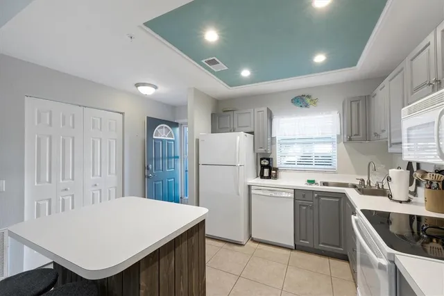a kitchen that has a sink a stove and a refrigerator