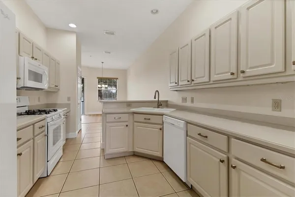 a kitchen with granite countertop white cabinets stainless steel appliances and sink