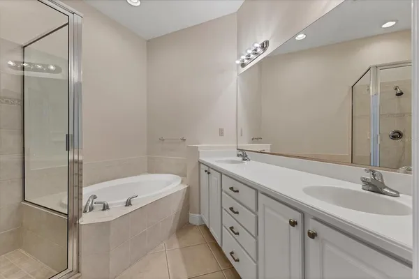 a bathroom with a tub sink shower and mirror