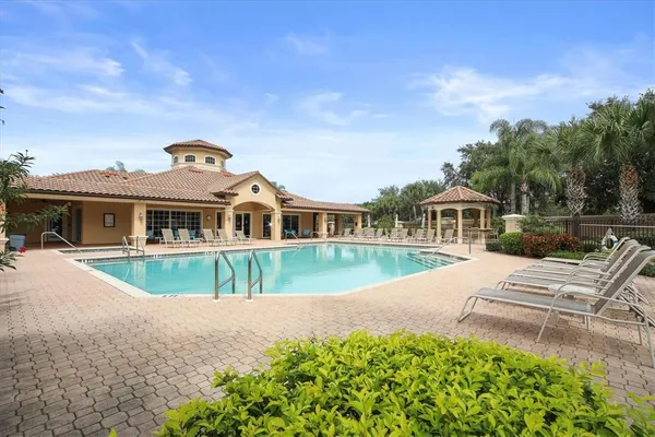 a view of a house with pool and chairs