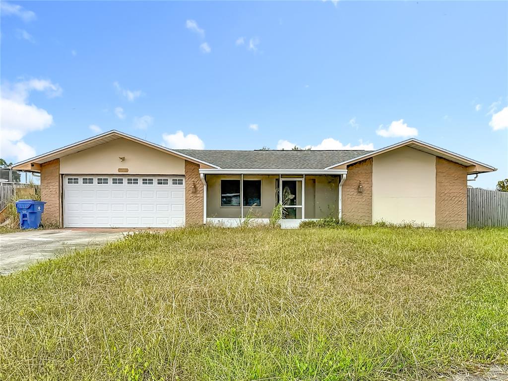 7012 Pin Cherry Lane Port Richey, FL 34668 - Photo 1 of 1 a view of a house with a yard and garage