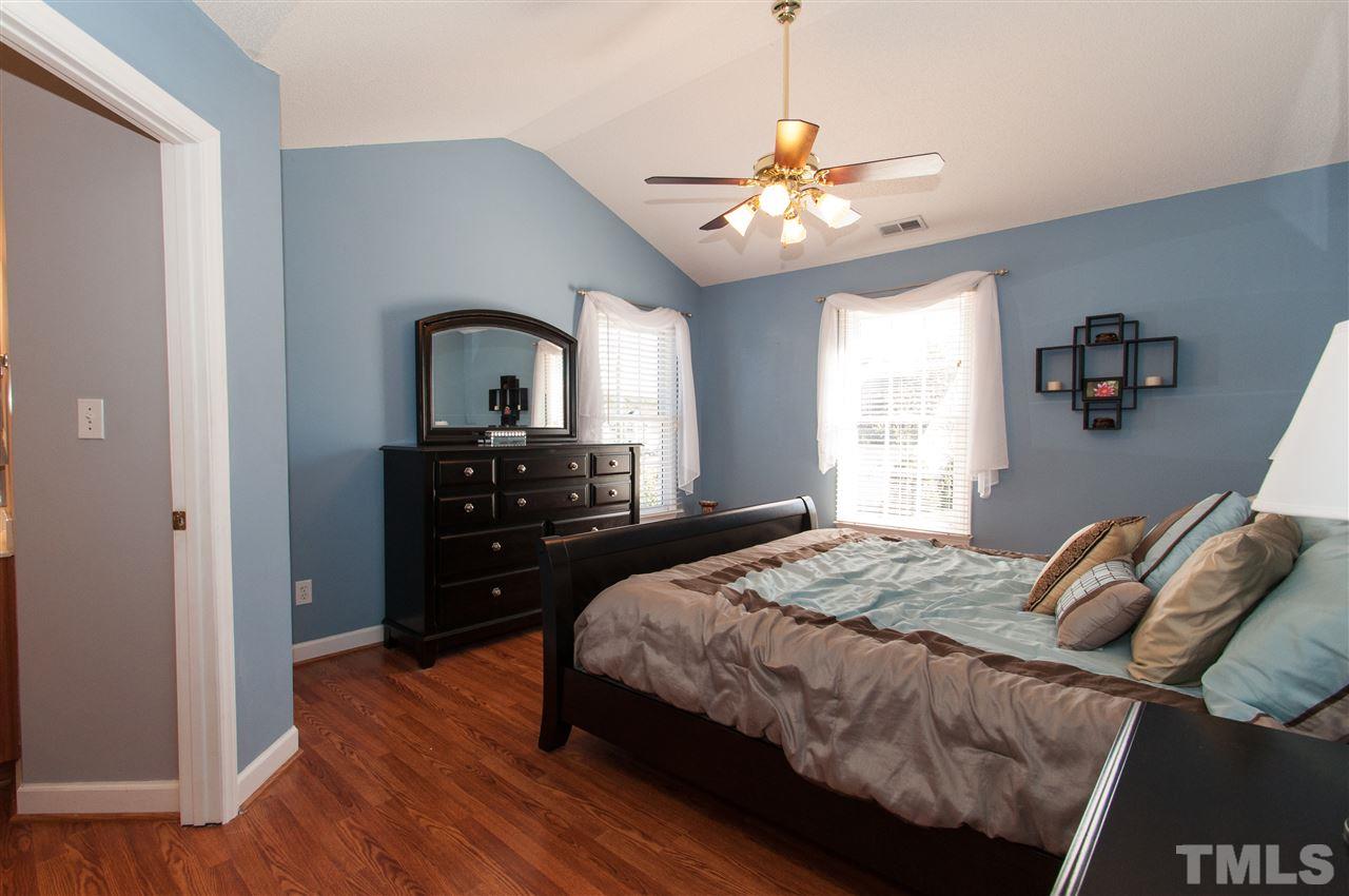 3205 Arden Branch Lane Raleigh, NC 27616 - Photo 13 of 22 a bedroom with a bed and a chandelier