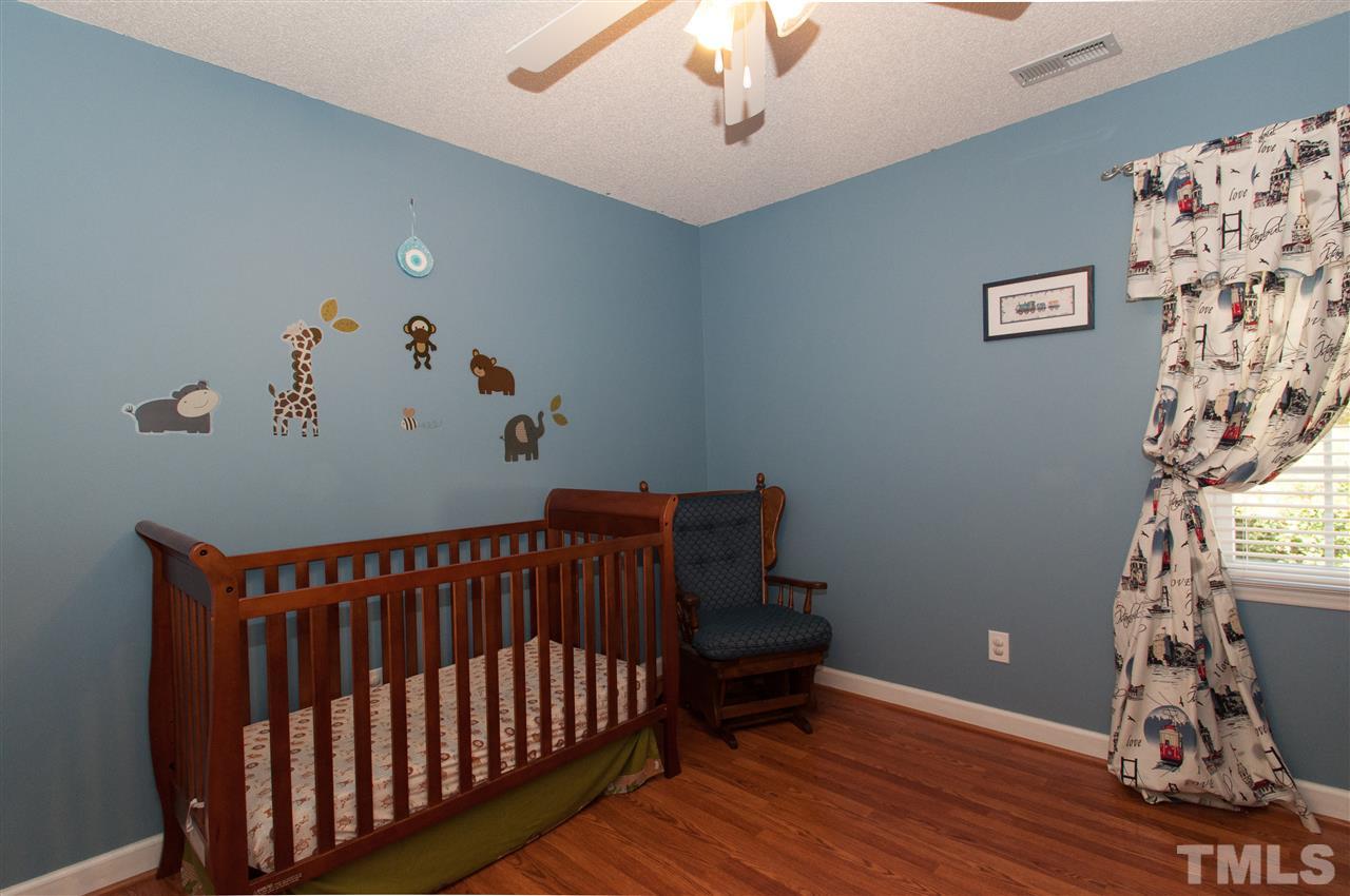 3205 Arden Branch Lane Raleigh, NC 27616 - Photo 15 of 22 a bedroom with a bed and wooden floor