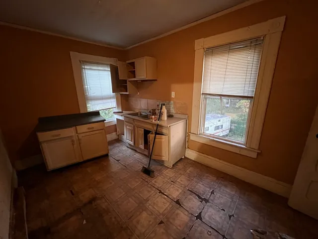 a kitchen with granite countertop a stove a sink and a microwave