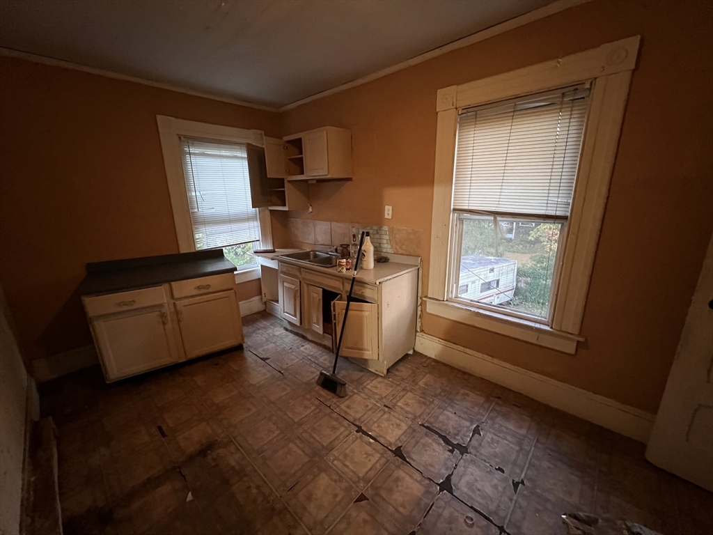 34 Wellesley Street Springfield, MA 01109 - Photo 11 of 11 a kitchen with granite countertop a stove a sink and a microwave