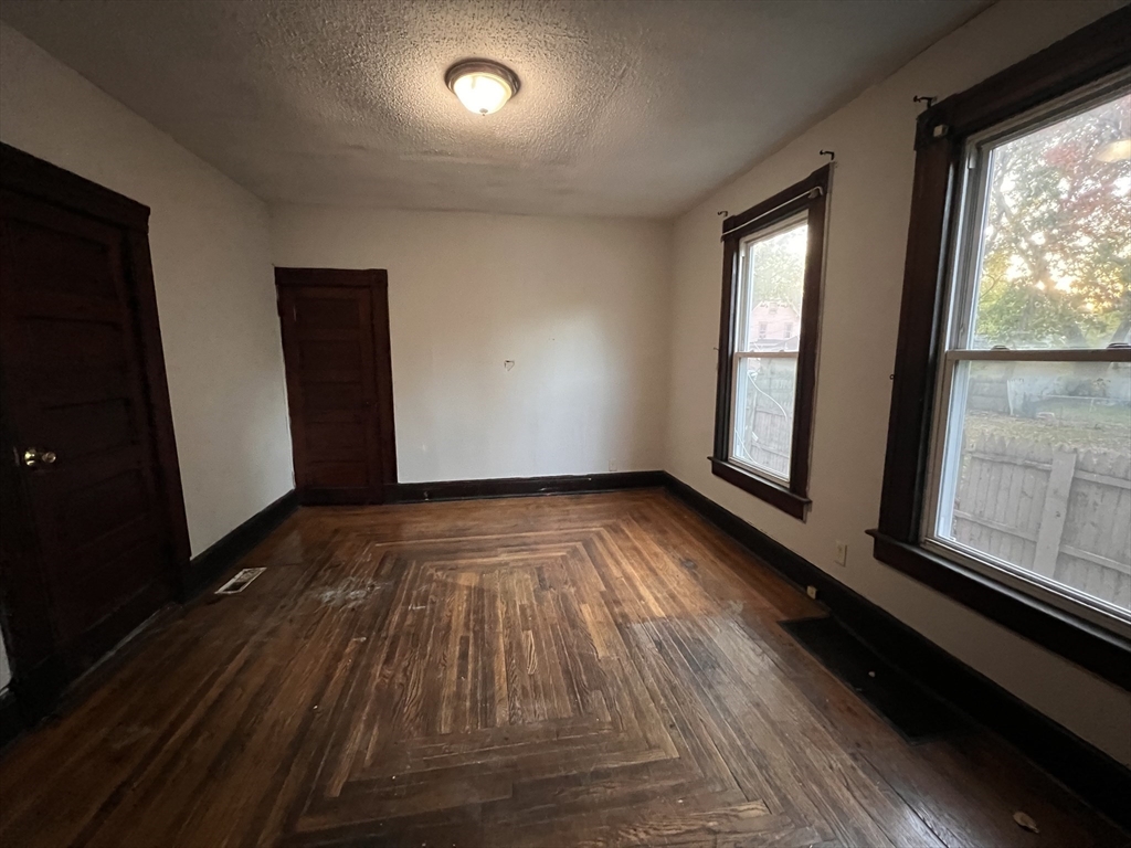 34 Wellesley Street Springfield, MA 01109 - Photo 7 of 11 wooden floor in an empty room with a window