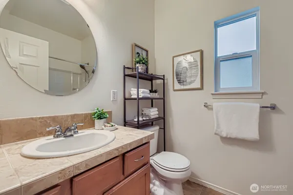 a bathroom with a granite countertop sink toilet and a mirror
