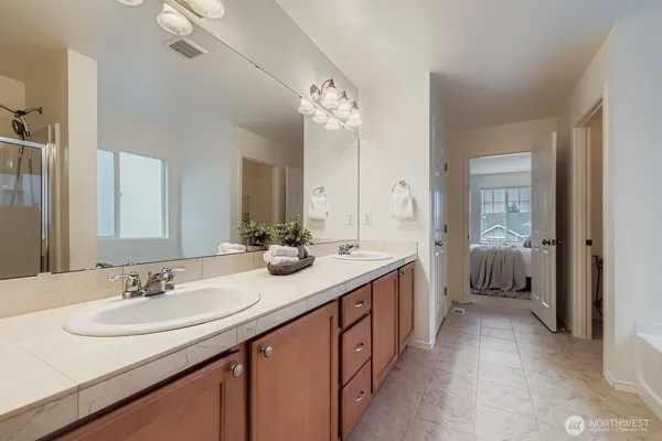 a en suite bathroom with a double vanity sink and a mirror