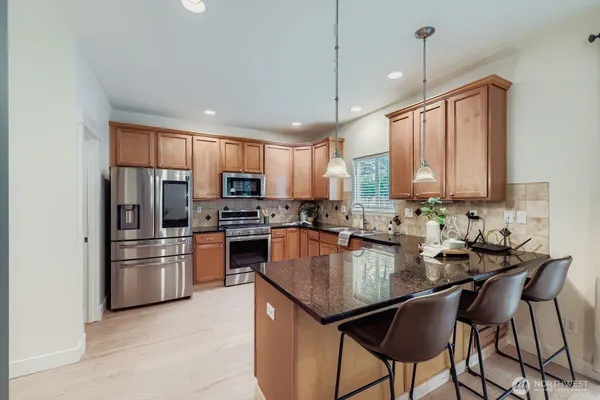 a kitchen with kitchen island a large counter top space appliances and cabinets