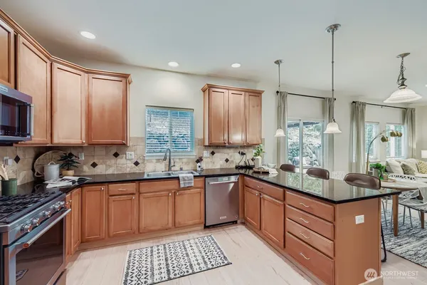 a kitchen with stainless steel appliances granite countertop a sink stove and cabinets