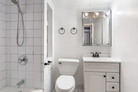 a bathroom with a toilet sink and mirror