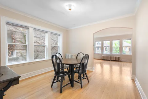 a view of a dining room with furniture a chandelier and wooden floor
