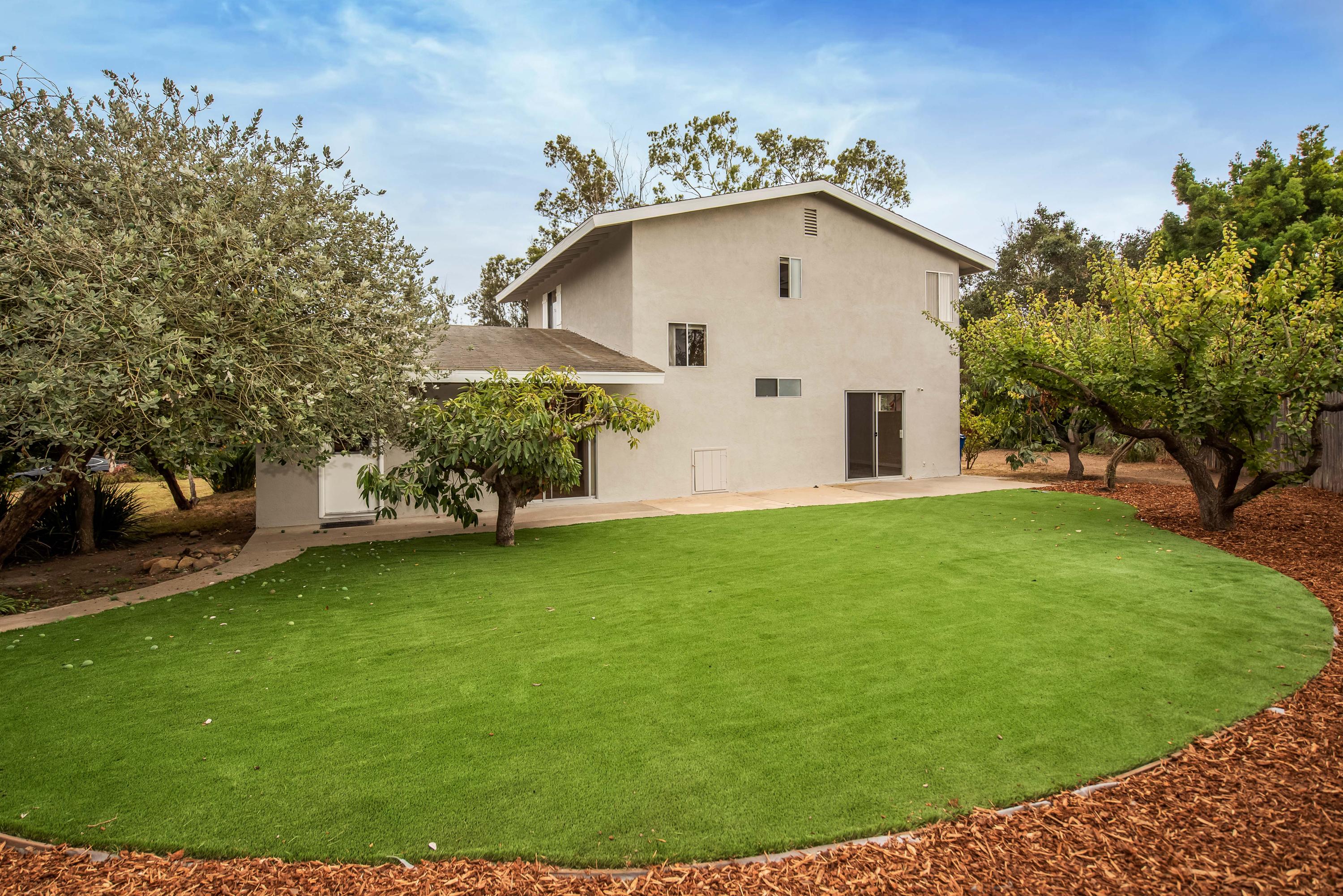 7458 Shepard Mesa Road Carpinteria, CA 93013 - Photo 15 of 17 a view of a white house with a big yard and potted plants