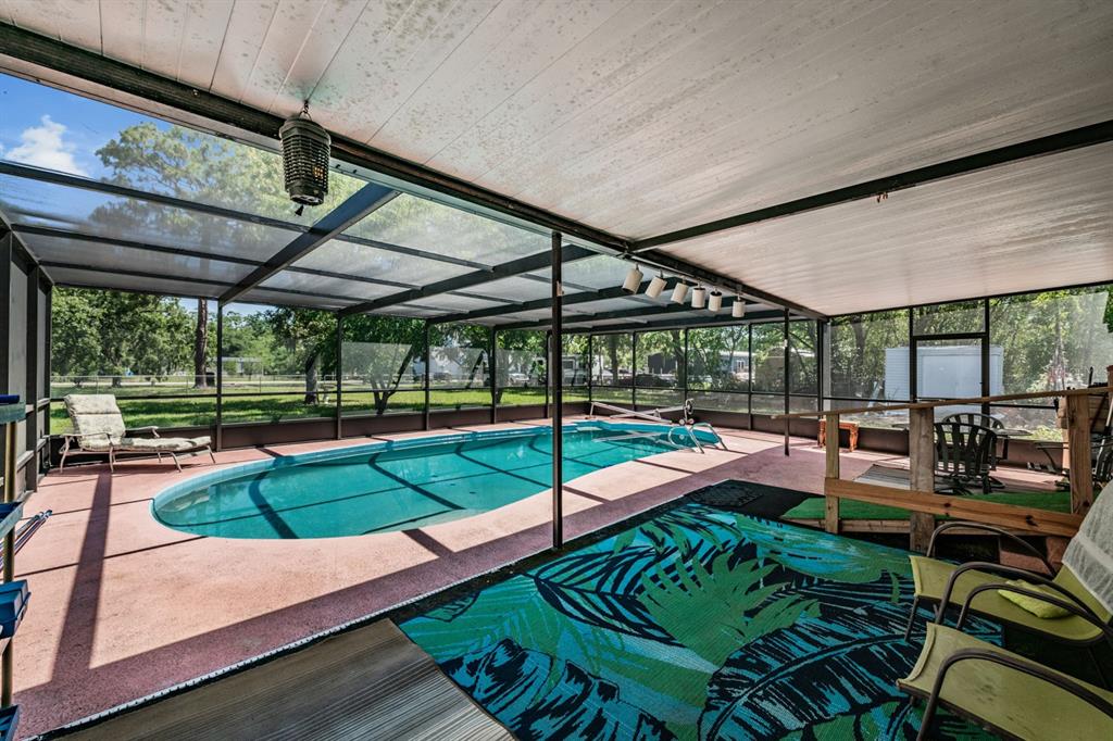 9739 Ray Street Hudson, FL 34669 - Photo 2 of 36 a view of a patio with table and chairs potted plants with wooden floor and fence