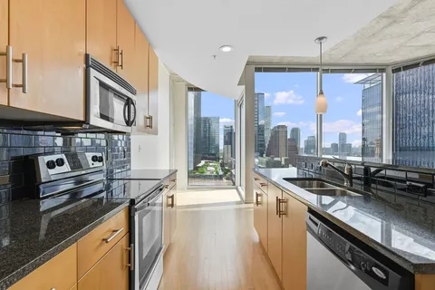 a kitchen with stainless steel appliances granite countertop a sink and a stove