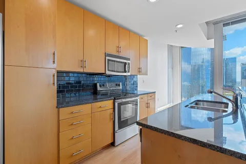 a kitchen with stainless steel appliances a sink a stove and a wooden floors