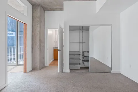 a view of a hallway with wooden floor and a living room