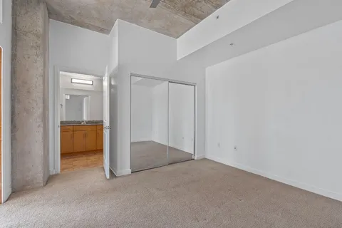 an empty room with closet and mirrors