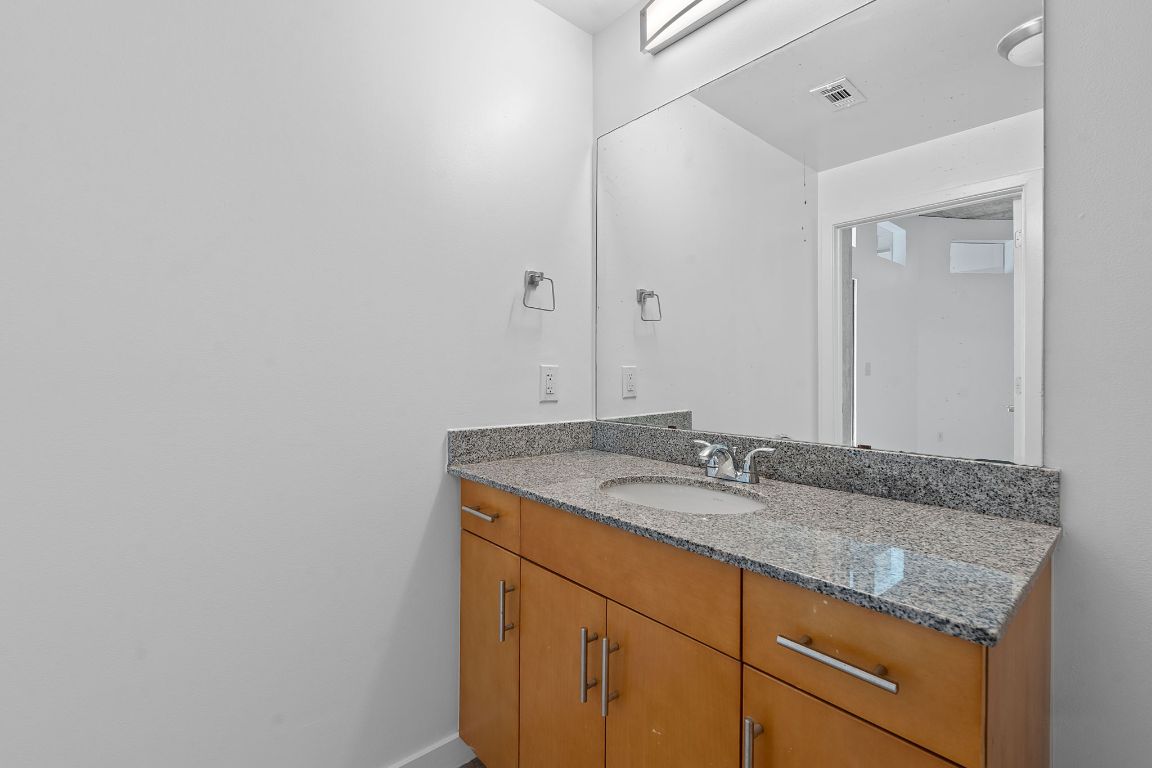 360 Nueces Street, Unit 2401 Austin, TX 78701 - Photo 23 of 40 a bathroom with a granite countertop sink and a mirror