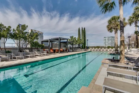 a view of swimming pool with outdoor seating and house in the background