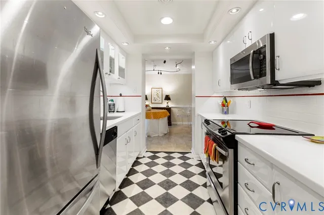 a kitchen with stainless steel appliances granite countertop a refrigerator and a stove top oven