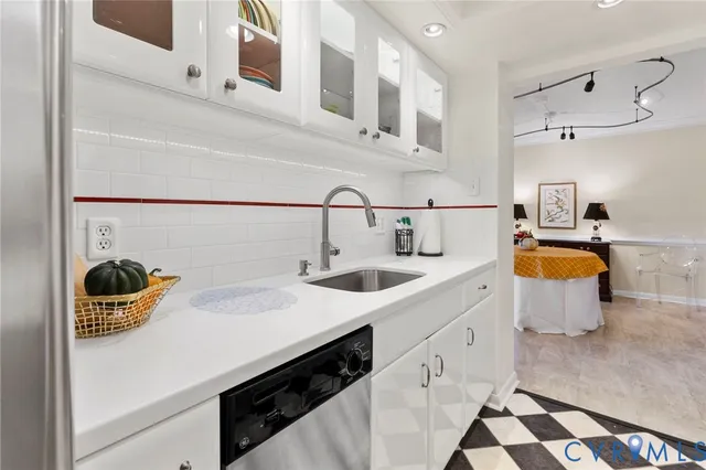 a kitchen with a sink and a stove next to a white cabinet