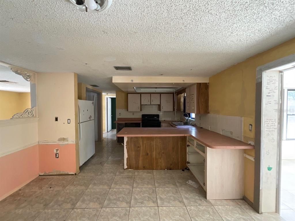 15839 Hicks Road Hudson, FL 34667 - Photo 3 of 16 a kitchen with stainless steel appliances granite countertop a refrigerator and a sink