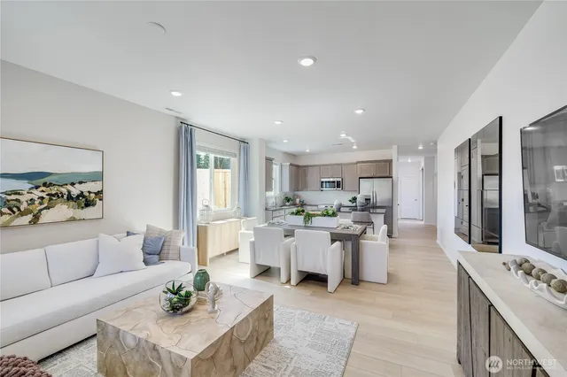 a living room with lots of furniture and view of kitchen
