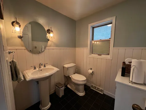a bathroom with a toilet sink and mirror