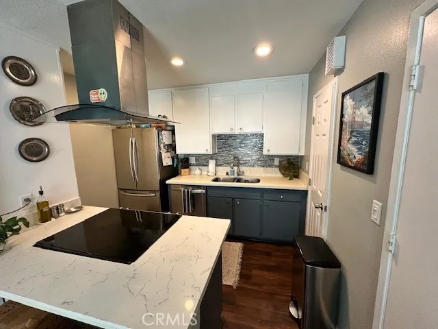 a kitchen with a refrigerator and a stove top oven