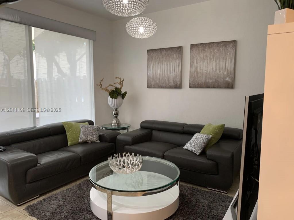 12450 Southwest 125th Terrace, Unit 12450 Miami, FL 33186 - Photo 12 of 23 a living room with furniture and a dining table