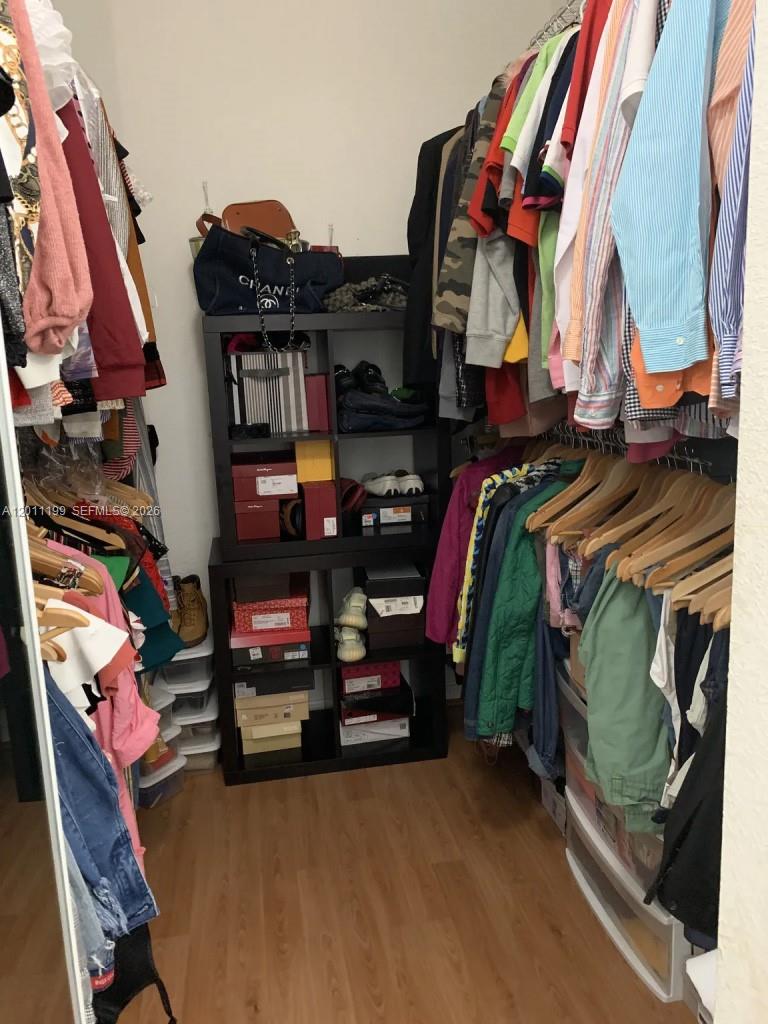12450 Southwest 125th Terrace, Unit 12450 Miami, FL 33186 - Photo 13 of 23 a view of walk in closet with clothes and shoes