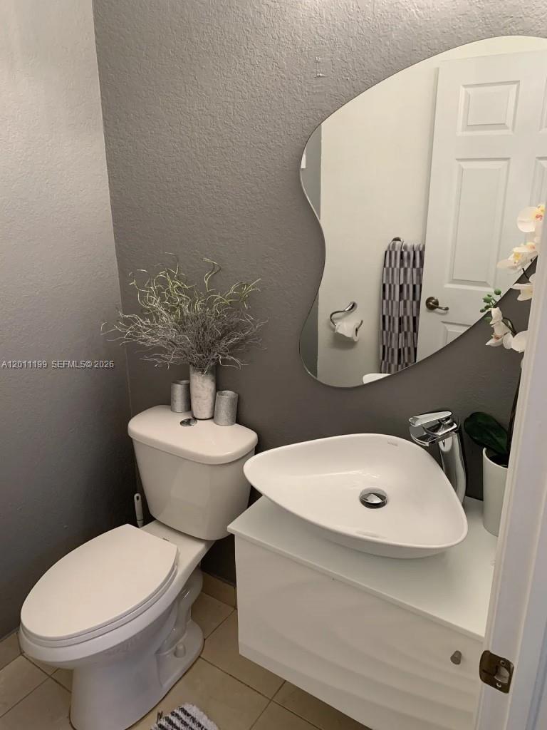 12450 Southwest 125th Terrace, Unit 12450 Miami, FL 33186 - Photo 14 of 23 a bathroom with a toilet sink and mirror