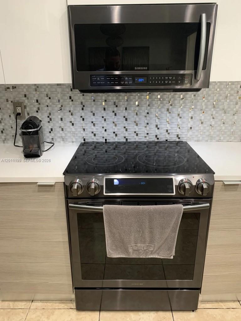 12450 Southwest 125th Terrace, Unit 12450 Miami, FL 33186 - Photo 17 of 23 a close view of stove top oven with granite counter top