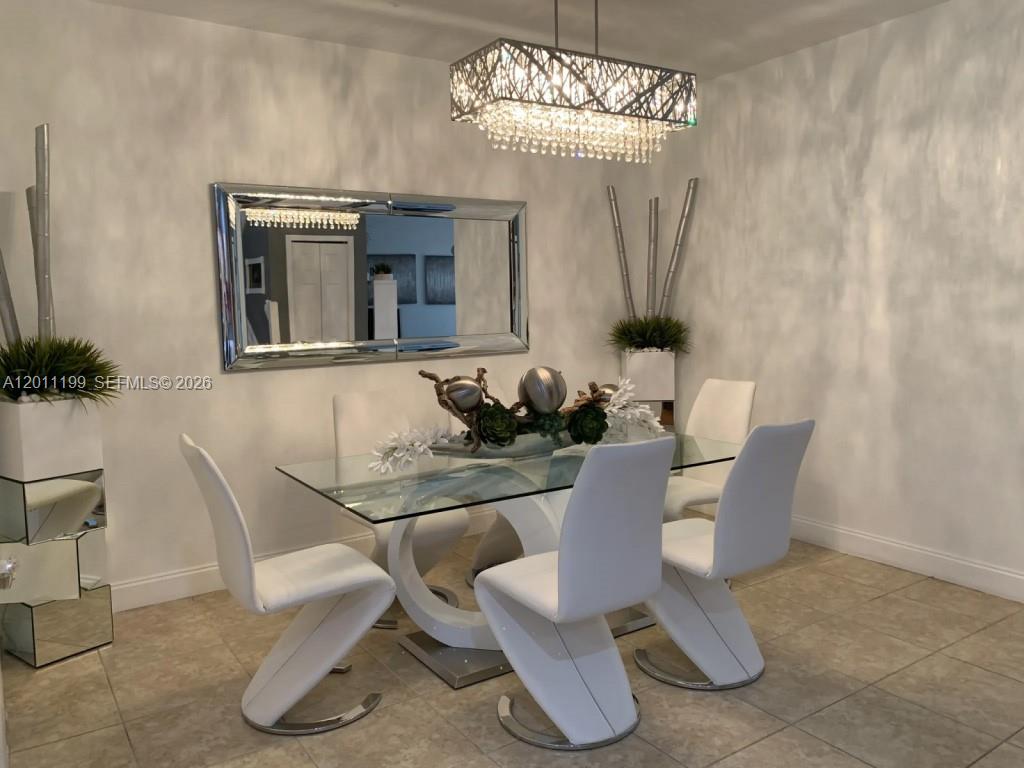 12450 Southwest 125th Terrace, Unit 12450 Miami, FL 33186 - Photo 18 of 23 a dining room with furniture and chandelier