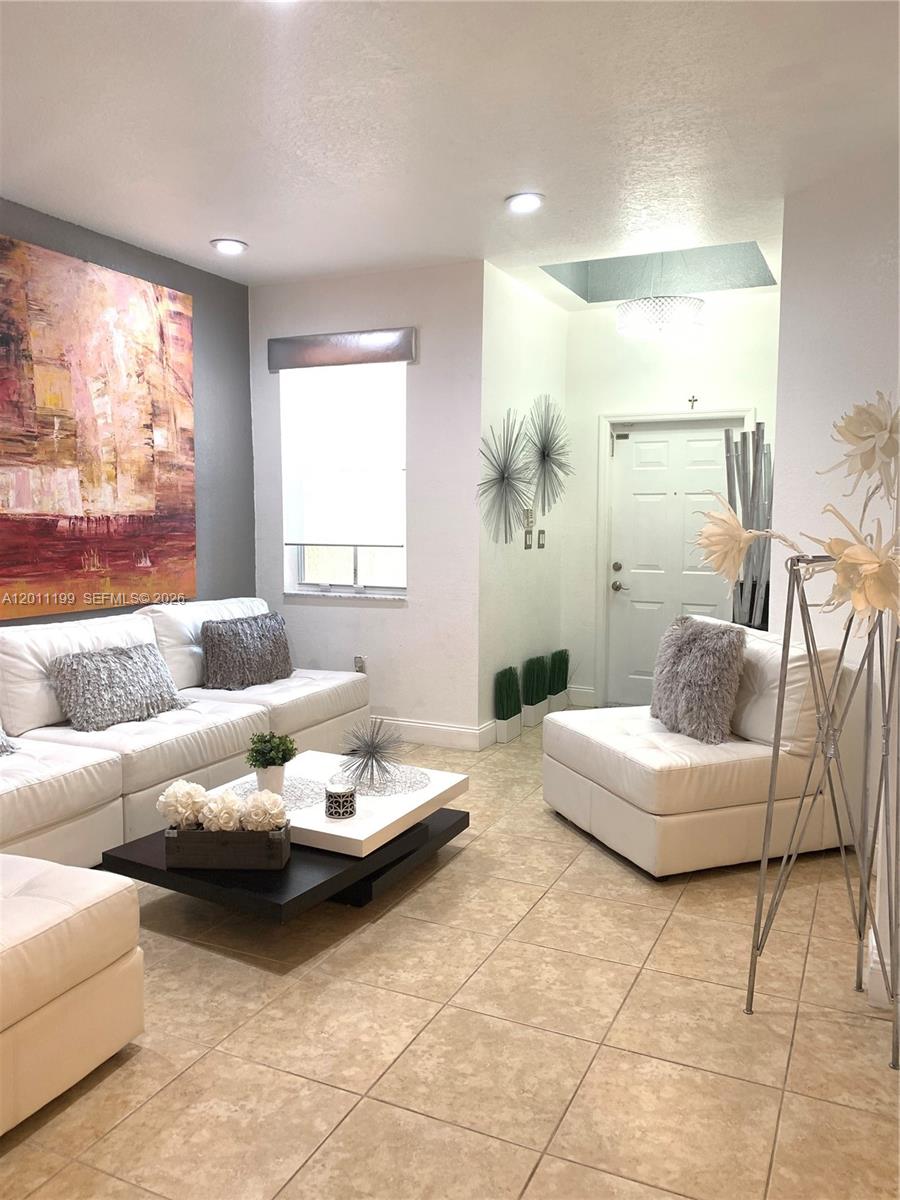 12450 Southwest 125th Terrace, Unit 12450 Miami, FL 33186 - Photo 2 of 23 a living room with furniture and a large window