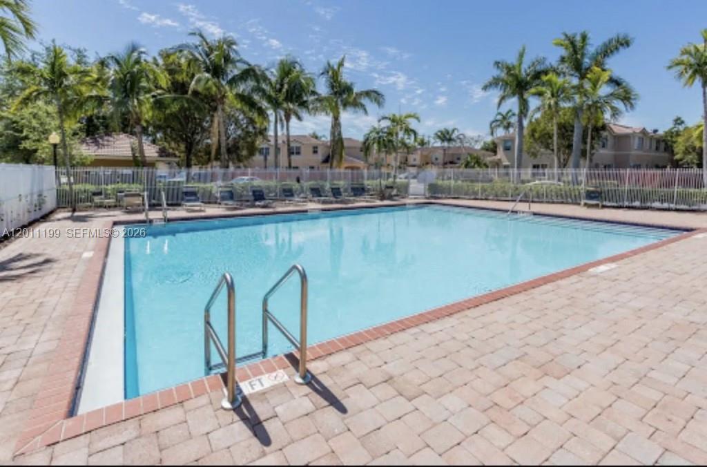 12450 Southwest 125th Terrace, Unit 12450 Miami, FL 33186 - Photo 5 of 23 a view of a swimming pool and lounge chair