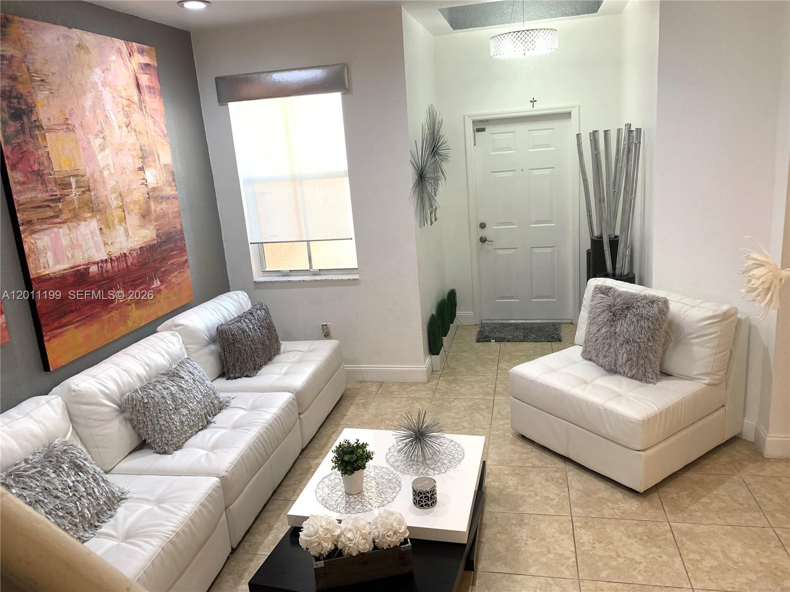 12450 Southwest 125th Terrace, Unit 12450 Miami, FL 33186 - Photo 6 of 23 a living room with furniture and a large window