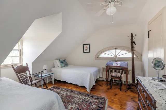 a bedroom with furniture a chandelier and a window