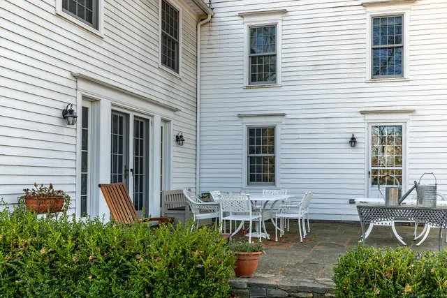 a backyard of a house with table and chairs