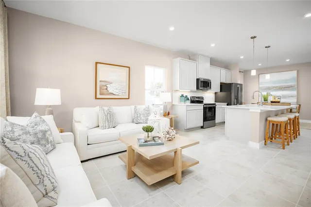 a living room with furniture and kitchen