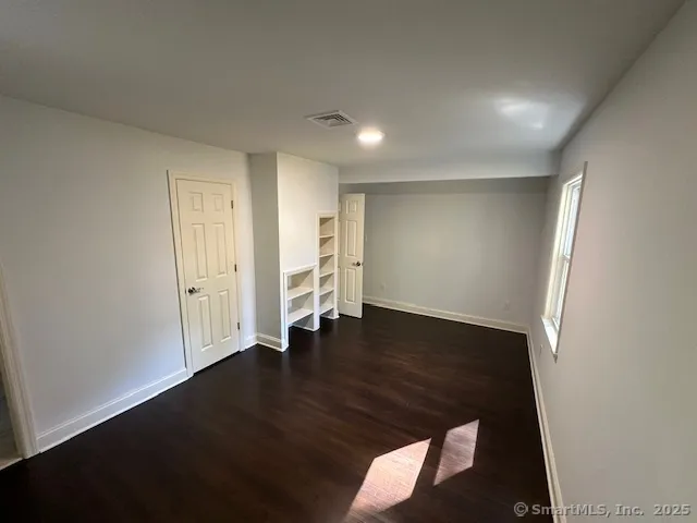 an empty room with wooden floor and closet