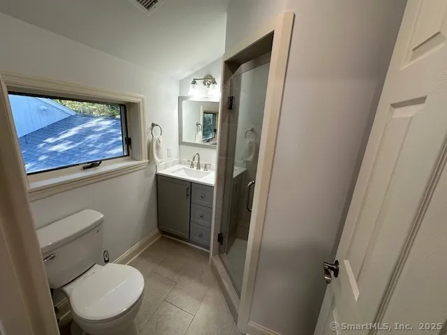 a bathroom with a toilet a sink and glass door