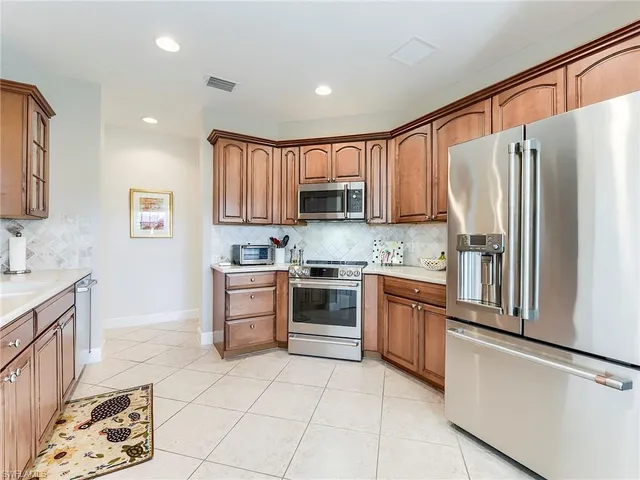 a kitchen with stainless steel appliances granite countertop a refrigerator sink and stove